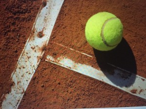 Tennis ball close to the line on a tennis court.