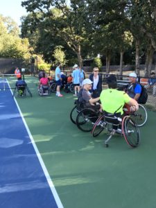 Wheelchair participants socializing during the tennis tournament.